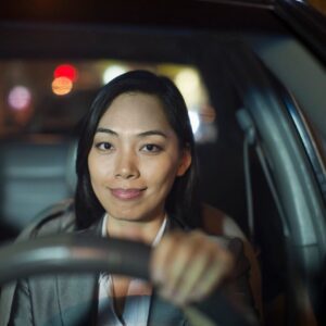 A woman sitting in the drivers seat of her car.