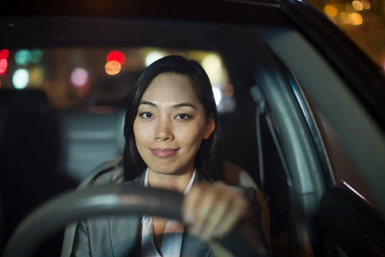 A woman sitting in the drivers seat of her car.