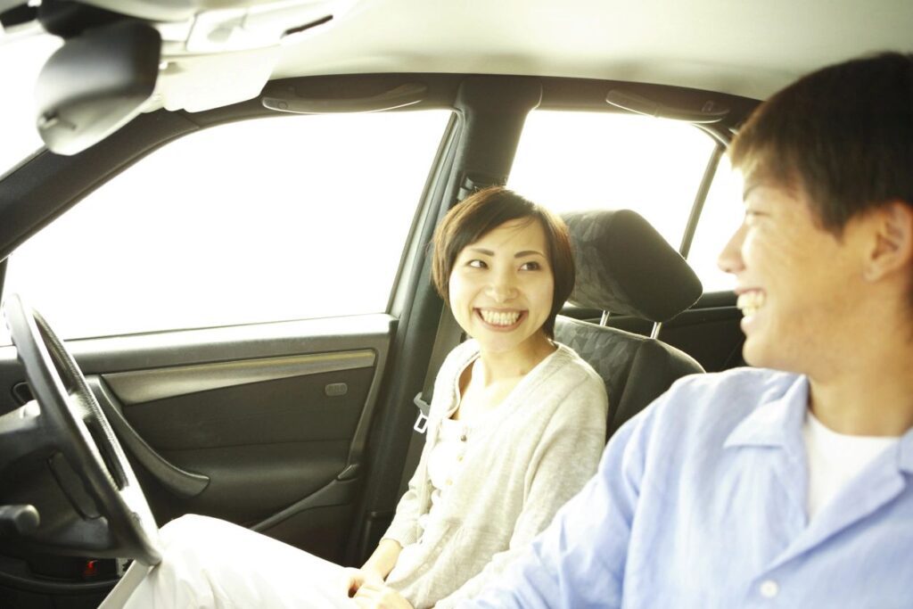 A man and woman sitting in the back of a car.