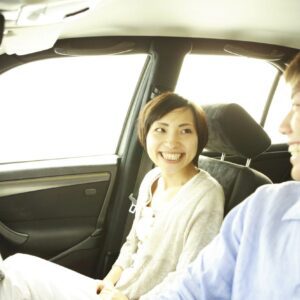 A man and woman sitting in the back of a car.